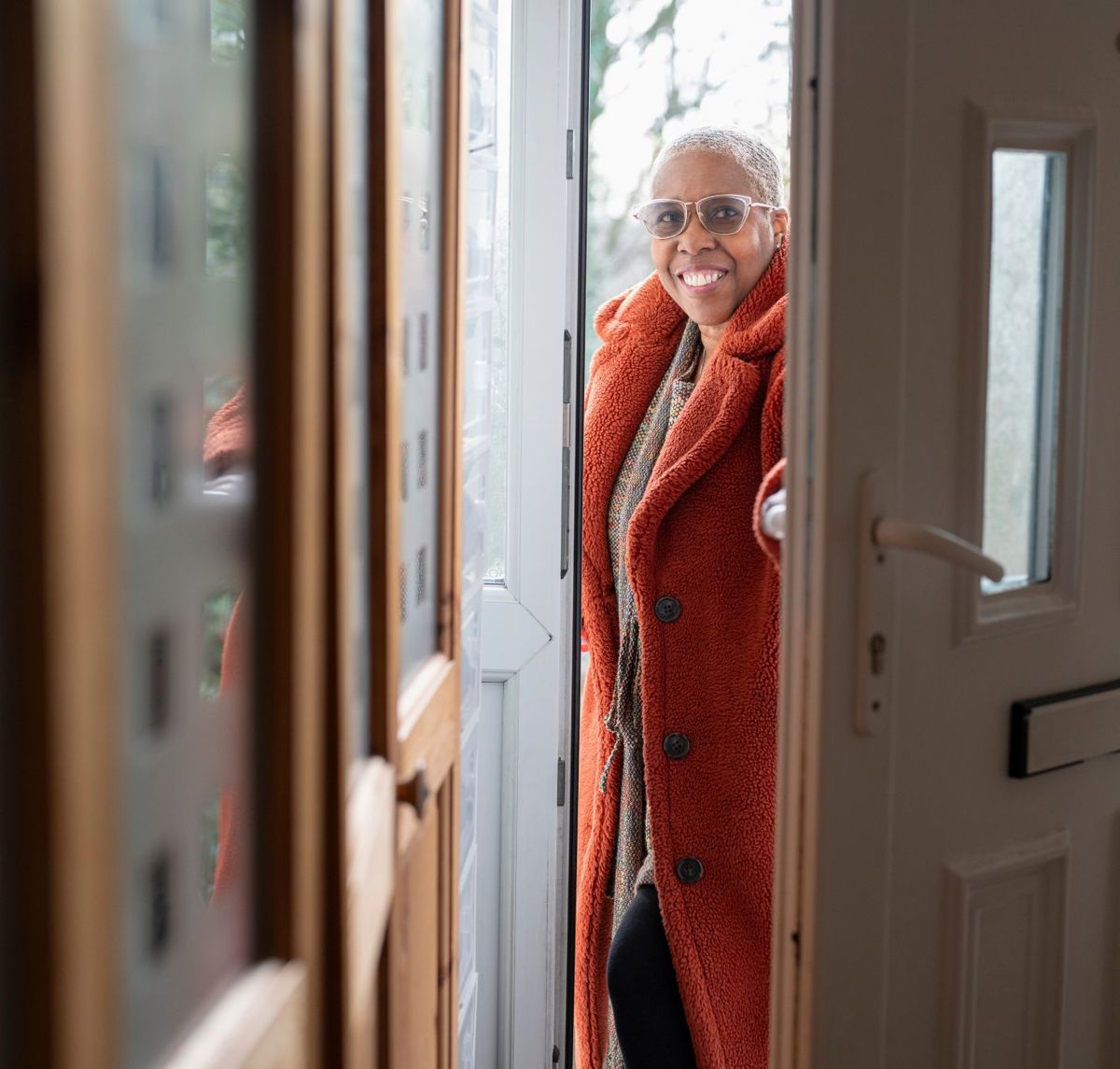 Older Woman Opening Her Front Door And Walking Inside Stock