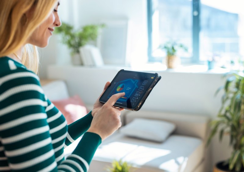 Woman Looking At Tablet Heating Control