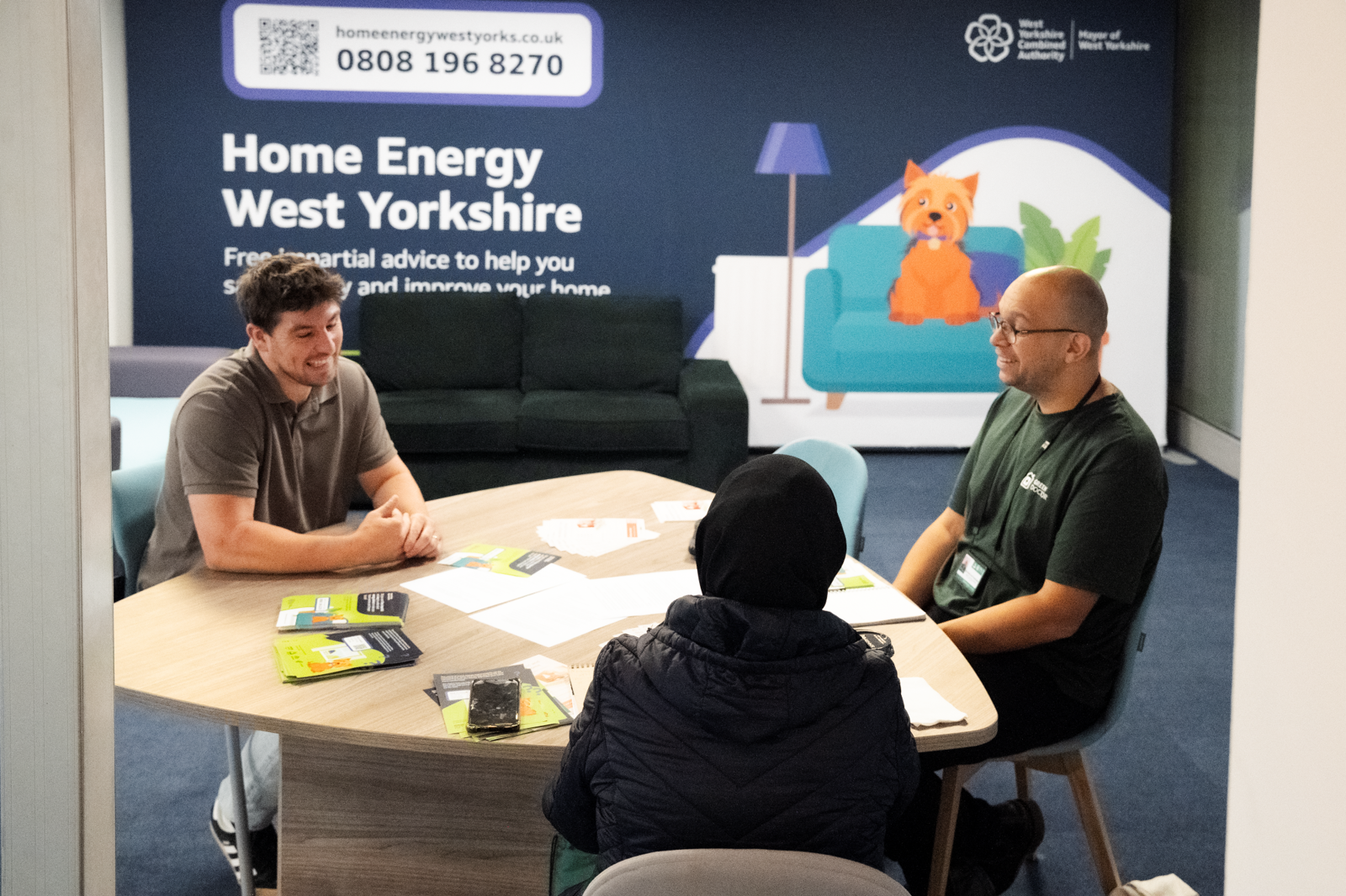 People sat talking at the Home Energy West Yorkshire pop-up shop in Bradford Interchange