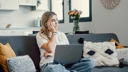 Concerned Woman Sat On Sofa