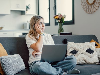 Concerned Woman Sat On Sofa